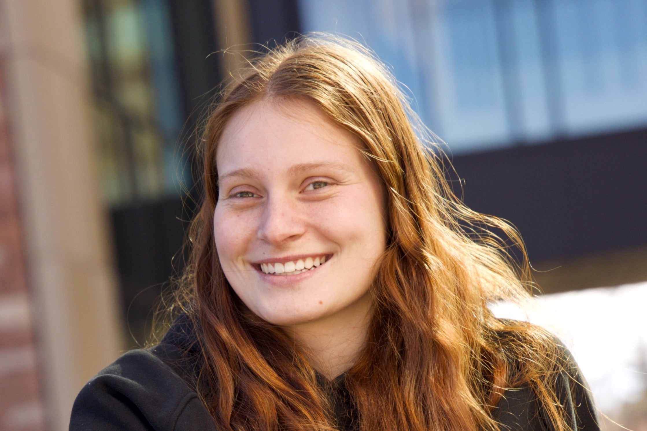 Portrait of Sevi outdoors smiling to radiate confidence