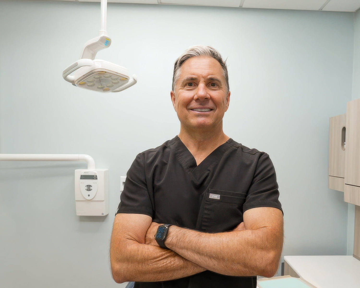 Dr. Chris smiling with floss tools on a white table